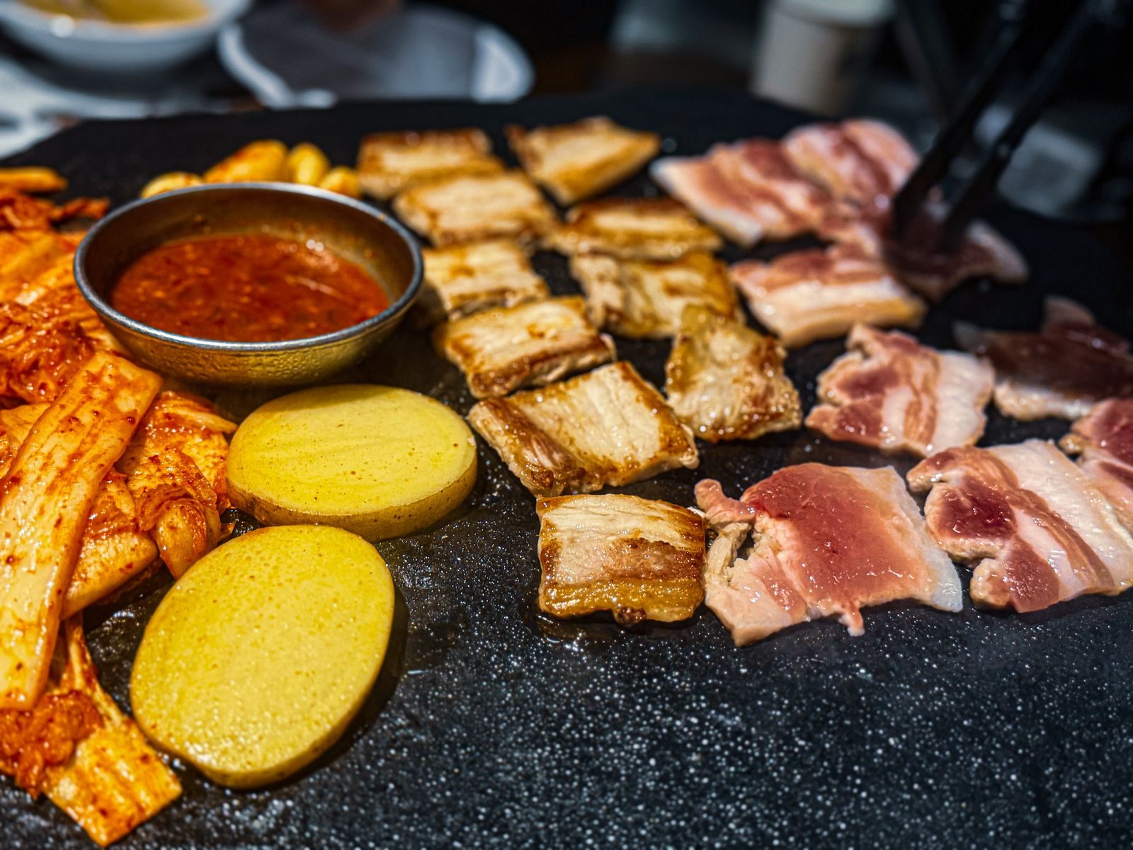 Pork belly and kimchi sizzling on a Korean grill
